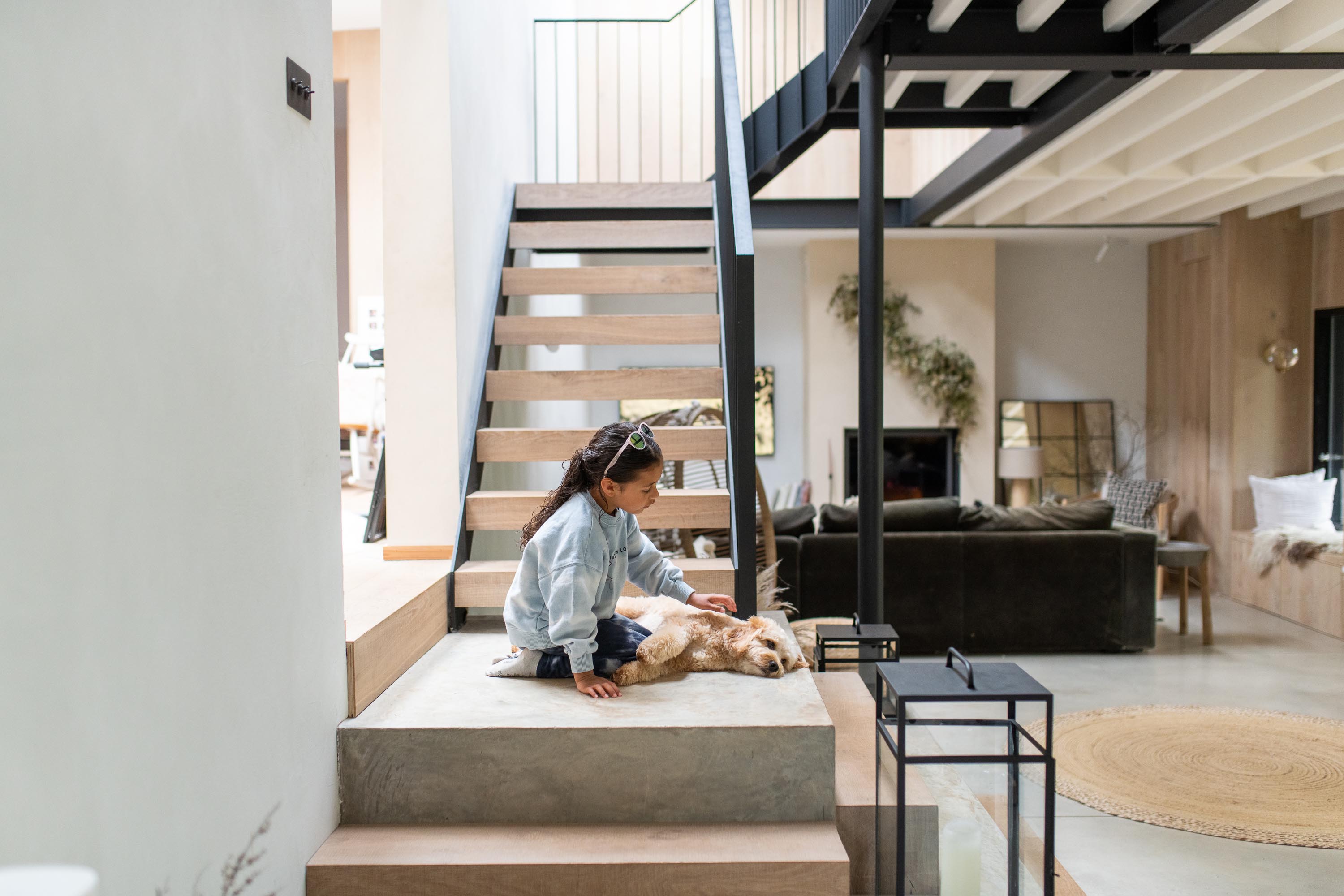girl with pet dog on the stairs under a rooflight 
